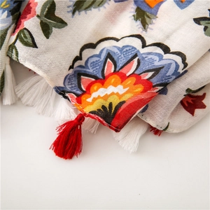 Detailed macro view of ethnic floral print fabric with red and white fringe tassels