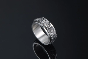 Detailed macro of vintage dragon relief on rotatable stainless steel punk ring