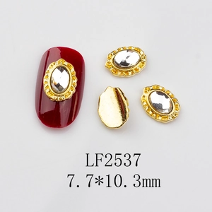 Detailed view of LF2537 oval crystal nail charm with gold lace on red nail tip