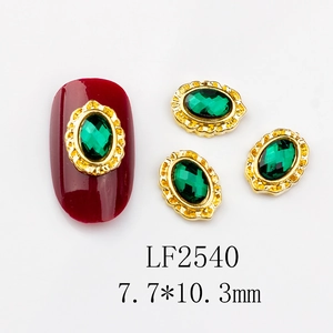 Close-up of vintage emerald green alloy nail art charms with gold floral borders