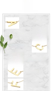 Detail view of gold stainless steel initial pendants A-F on marble background