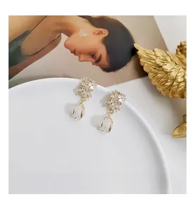 Detailed view of floral vintage earrings with shell petals and gold metal finish