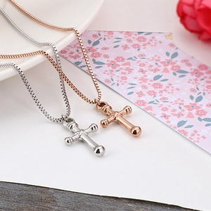 Polished silver and rose gold stainless steel cross pendant necklaces on white background