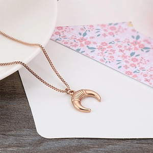 Minimalist rose gold moon pendant necklace with delicate box chain on a wooden table