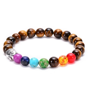 Macro shot of tiger eye chakra bracelet featuring a silver Buddha head and colorful stones