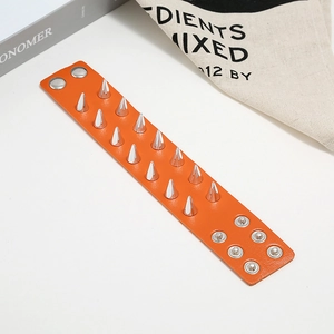 Orange punk leather bracelet featuring double rows of silver metal spikes on a white background