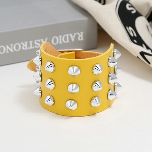 Close-up of yellow punk faux leather cuff bracelet featuring three rows of silver metal spikes