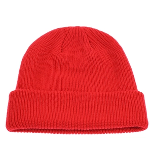 Macro detail of the bright red ribbed knit texture and warm fabric on the beanie hat