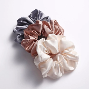 Three-piece satin scrunchies set in grey, champagne, and ivory with smooth silk-like texture