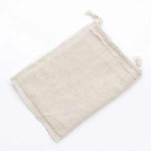 Detailed close-up of beige cotton linen drawstring pouch showing fabric texture and weave