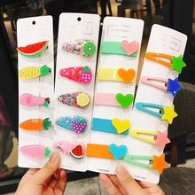 Close-up of assorted colorful fruit and heart hair clips on handmade display cards