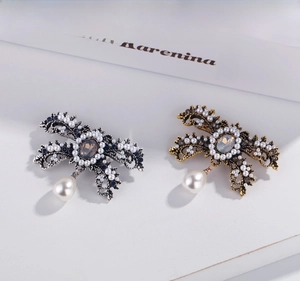 Detailed macro of vintage baroque bow brooches with water drop pearls and blue rhinestones