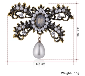 Detailed view of vintage bow brooch with pearls, dark rhinestones and 5.4cm width scale