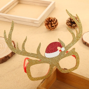 Golden glitter reindeer antler glasses with a small Christmas hat on a festive background