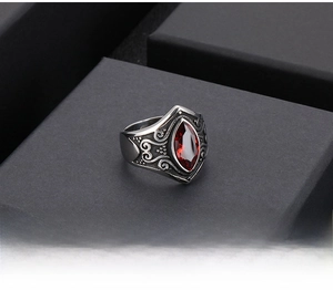 Macro shot of vintage stainless steel ring with red marquise stone and ornate engravings