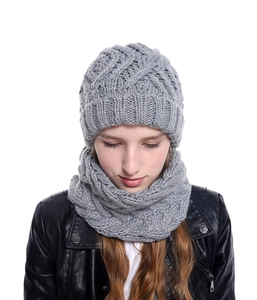 Detailed knit texture of a grey beanie and neck gaiter set on a female model