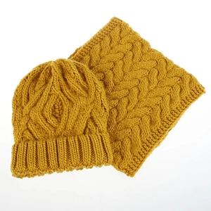 Close-up of yellow winter knit set featuring thick cable pattern on beanie and cowl scarf