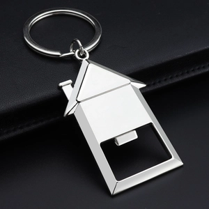 Polished silver house-shaped metal bottle opener keychain on black leather background