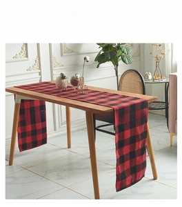 Classic red and black plaid table runner close-up on a wooden table for festive decor