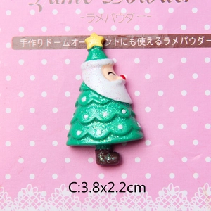 Macro view of a 3.8x2.2cm resin Christmas tree flatback with Santa face and gold glitter