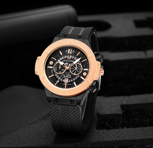 Detail of rose gold bezel chronograph watch with black silicone strap and date display