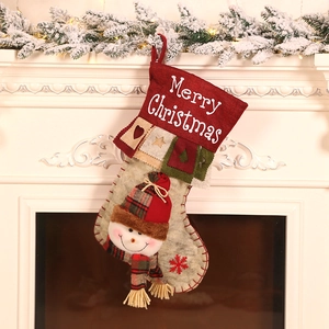 Christmas burlap stocking with 3D snowman hanging on white fireplace with warm lighting