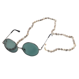 Detail of vintage round sunglasses with dark green lenses and natural shell beaded strap