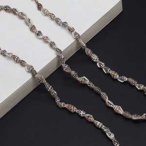 Detail of natural brown and white seashell beads on a stylish eyewear chain strap