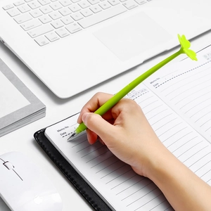 Creative green clover-shaped gel pen shown writing in a minimalist office setting