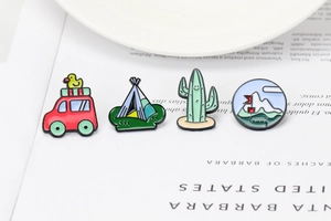 Lot détaillé de 4 pin's émaillés colorés avec voiture, tente, cactus et motif montagne