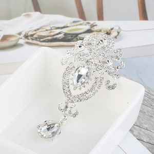 Detailed macro view of a silver baroque brooch featuring sparkling rhinestones and crystal teardrops