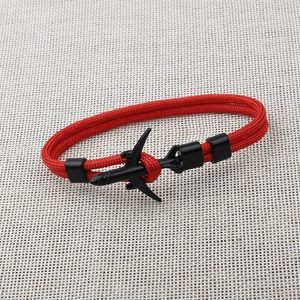 Close-up of red braided polyester rope bracelet with black metal airplane clasp detail