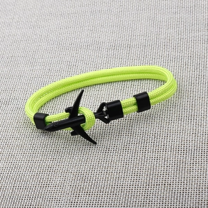 Detail of neon yellow paracord bracelet featuring a sleek black airplane anchor clasp