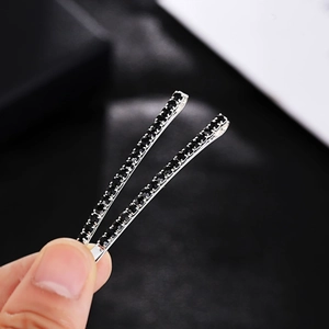 Close-up of elegant silver hair clips with sparkling black rhinestones in hand