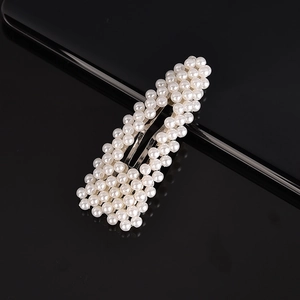 Macro detail of elegant rectangular hair clip with polished white pearls and silver base