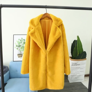 Détail d'un manteau en fausse fourrure jaune vif avec texture douce et col à revers