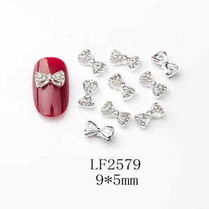 Macro de breloques nœud 9x5mm pour nail art avec cristaux sur des ongles rouges