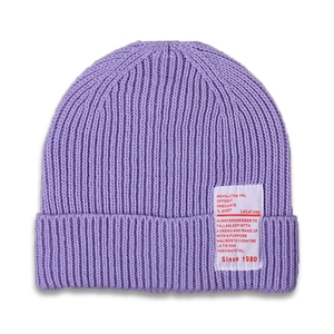 Detail view of the purple ribbed knit texture and white fabric label on children beanie