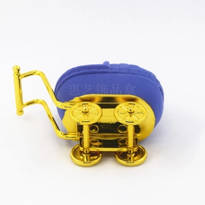 Detail of blue flocked baby stroller jewelry box with polished gold-plated metal wheels