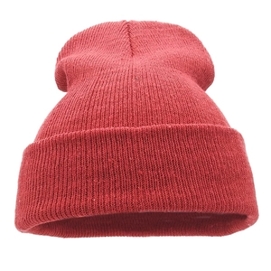 Detailed texture of red knitted winter beanie featuring a classic ribbed fold-over cuff