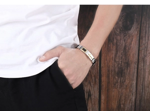 Close-up of a men's stainless steel and black silicone religious cross bracelet on wrist