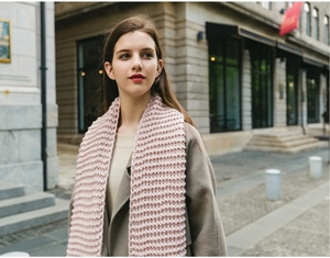 Detail of soft pink chunky knit scarf on a model with thick texture for winter warmth