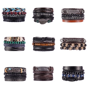 Macro view of multi-layered braided leather bracelets with wooden beads and metal charms