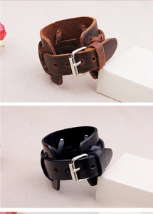 Vue détaillée de bracelets punk larges en cuir noir et marron avec boucles argentées