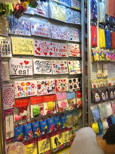 Close-up of assorted birthday party balloon stickers and banners stacked on store shelves