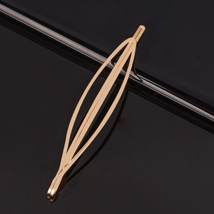 Barrette à cheveux minimaliste en métal doré évidé en forme de navette sur fond noir poli