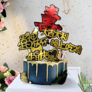 Macro shot of assorted festive cake toppers on a blue cake featuring gold lettering