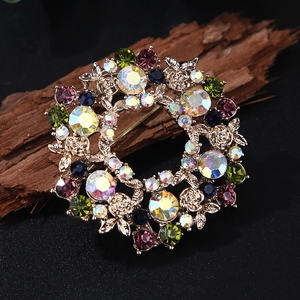 Luxurious vintage floral wreath brooch with colorful crystals on a rustic wood base