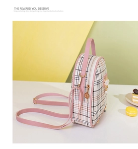 Detail of pink plaid mini backpack with pearl charm on a colorful geometric background