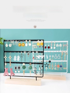Detail of multi-tier iron earring organizer with wooden base and multiple hanging holes